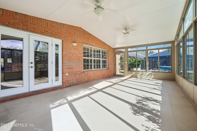 unfurnished sunroom featuring ceiling fan, a wealth of natural light, and vaulted ceiling