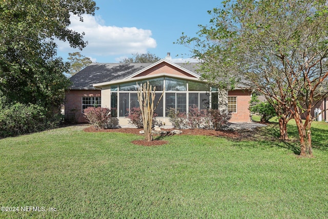 back of property featuring a yard and a sunroom