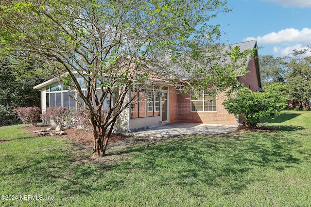 exterior space with a patio area, a yard, and a sunroom