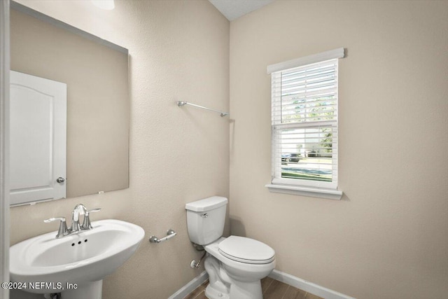 bathroom with toilet, wood-type flooring, and sink