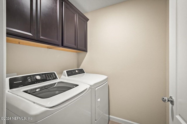 washroom featuring cabinets and washer and dryer