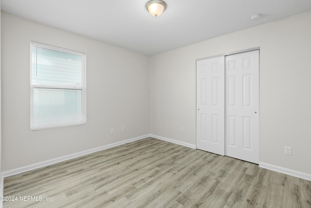 unfurnished bedroom featuring a closet and light hardwood / wood-style floors