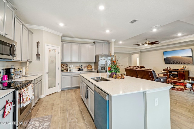 kitchen featuring gray cabinetry, crown molding, appliances with stainless steel finishes, and light hardwood / wood-style flooring