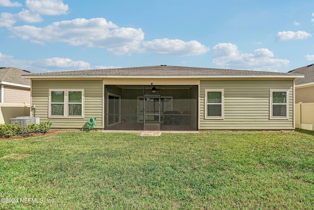 rear view of house with cooling unit and a lawn