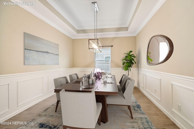 dining room with crown molding and a raised ceiling