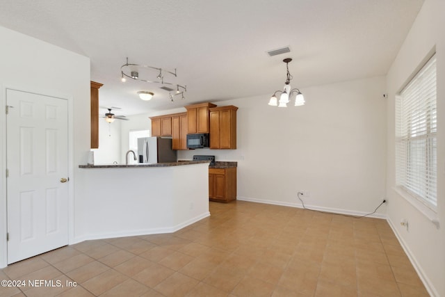 kitchen with kitchen peninsula, stainless steel fridge, light tile patterned floors, ceiling fan with notable chandelier, and decorative light fixtures