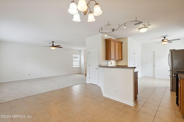 kitchen with hanging light fixtures, sink, stainless steel fridge, light tile patterned floors, and a chandelier