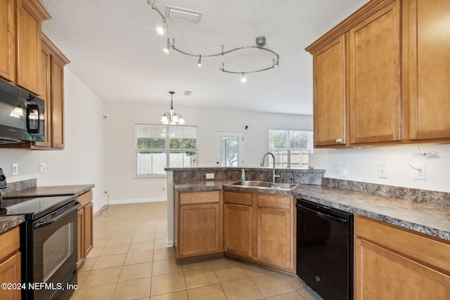 kitchen featuring a textured ceiling, black appliances, sink, and a wealth of natural light