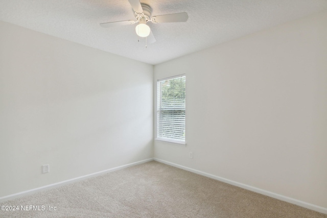 carpeted empty room featuring a textured ceiling and ceiling fan