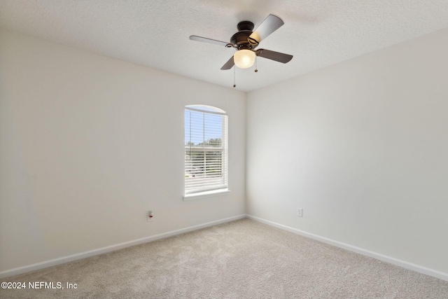 carpeted empty room with ceiling fan and a textured ceiling