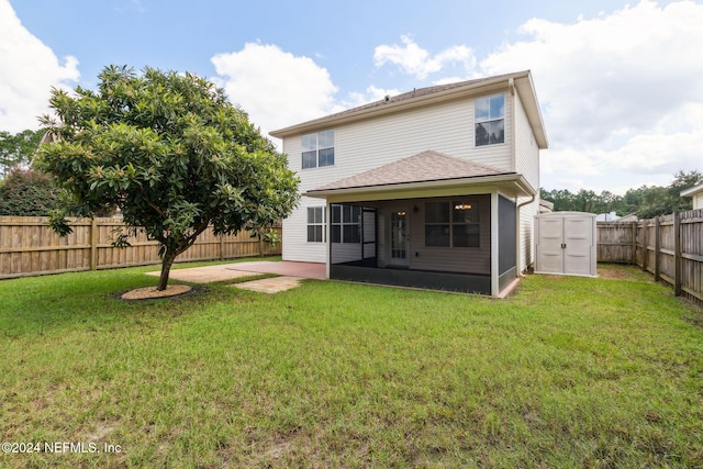 back of property featuring a yard, a patio, and a sunroom