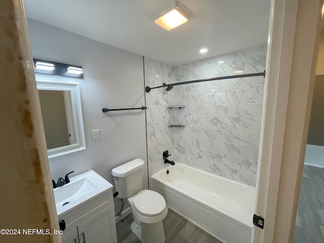 full bathroom featuring hardwood / wood-style floors, vanity, toilet, and tiled shower / bath combo