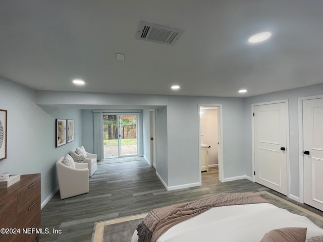 bedroom featuring dark hardwood / wood-style floors, ensuite bath, and access to outside