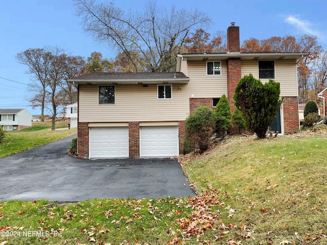 back of house featuring a garage and a lawn