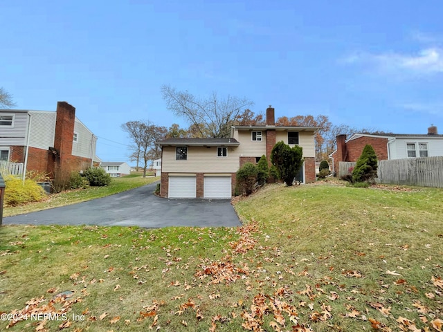 back of property featuring a garage and a yard