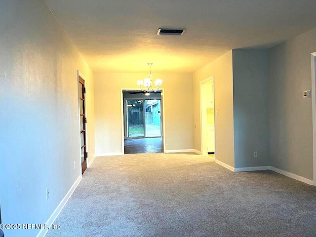 unfurnished room with a notable chandelier and carpet flooring