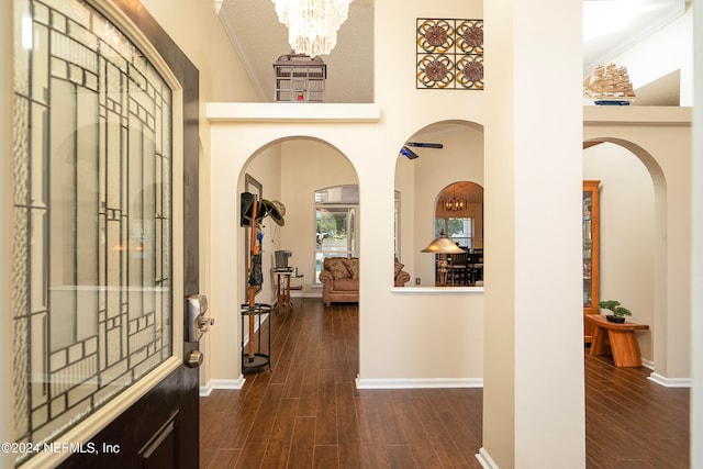 entrance foyer featuring ornamental molding, a chandelier, and dark hardwood / wood-style floors