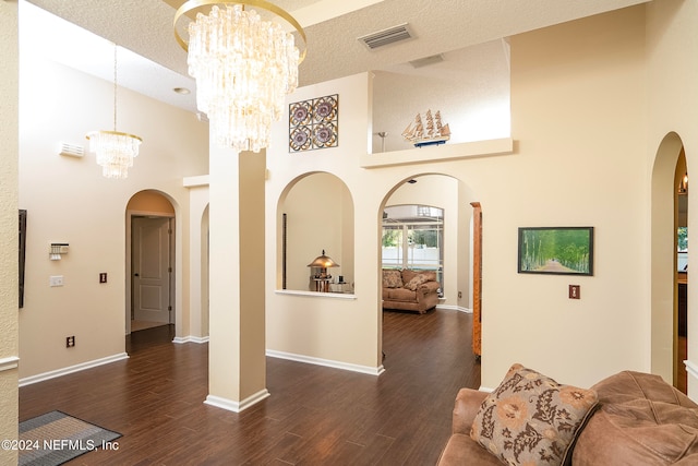 interior space with high vaulted ceiling, a textured ceiling, and dark hardwood / wood-style floors