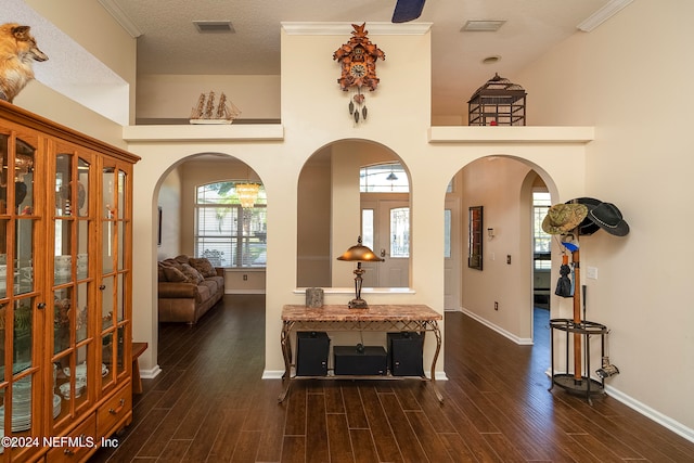 interior space with crown molding, a textured ceiling, high vaulted ceiling, and dark hardwood / wood-style flooring