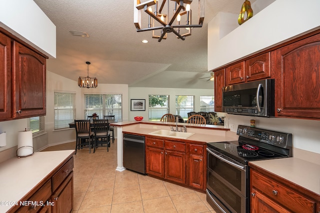 kitchen featuring appliances with stainless steel finishes, sink, a textured ceiling, hanging light fixtures, and vaulted ceiling