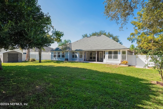 back of house featuring a yard and a storage unit