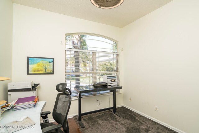 office area with dark colored carpet and a textured ceiling