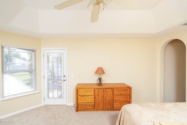 carpeted bedroom featuring multiple windows and ceiling fan