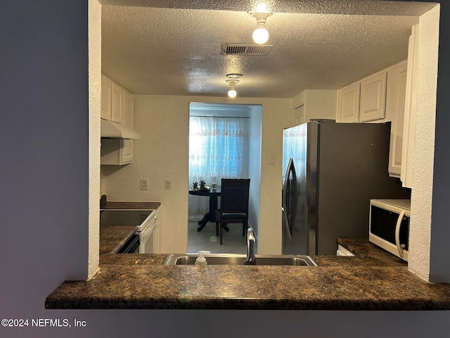 kitchen with white cabinetry, range with electric cooktop, stainless steel refrigerator, and sink