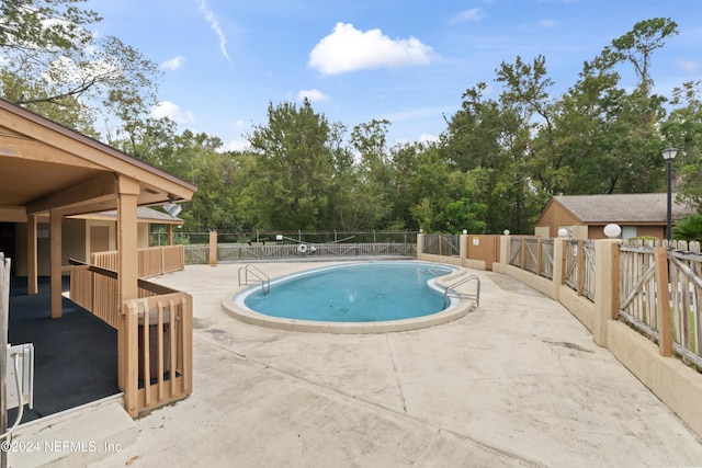 community pool featuring a patio and fence