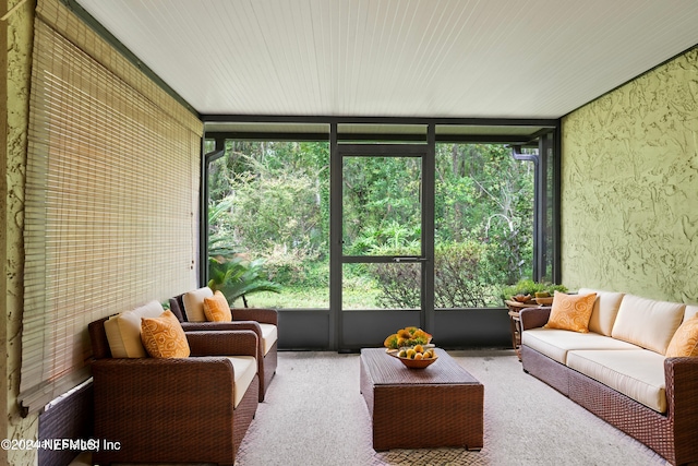 sunroom / solarium featuring carpet, expansive windows, and outdoor lounge area