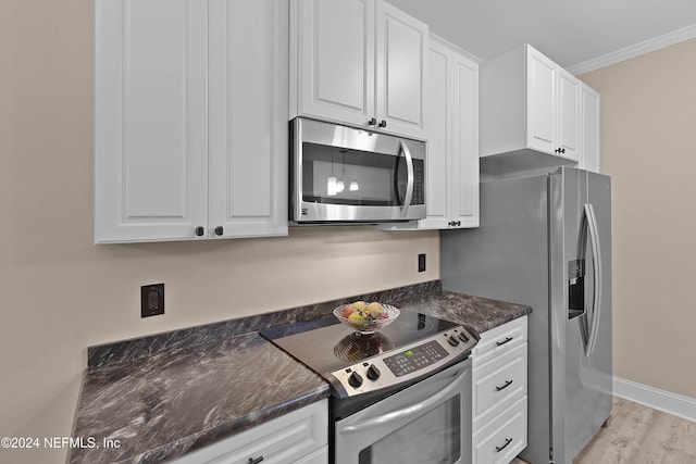 kitchen with white cabinetry, light hardwood / wood-style floors, appliances with stainless steel finishes, and ornamental molding