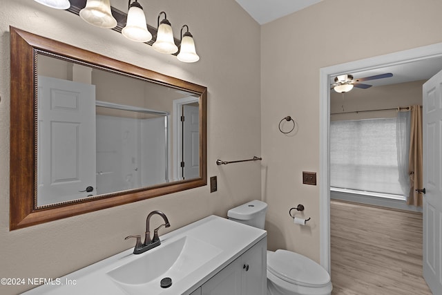 bathroom with toilet, ceiling fan, walk in shower, vanity, and hardwood / wood-style flooring