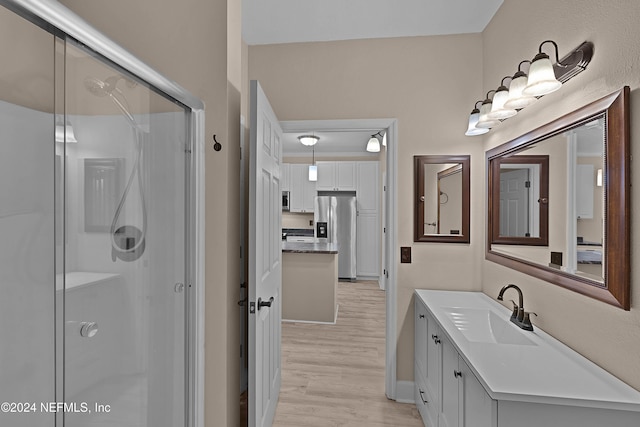 bathroom with vanity, hardwood / wood-style flooring, and walk in shower