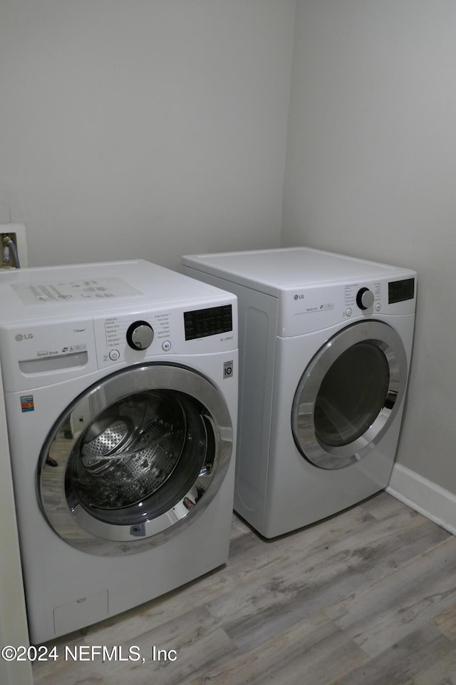 laundry room featuring light hardwood / wood-style flooring and washing machine and dryer