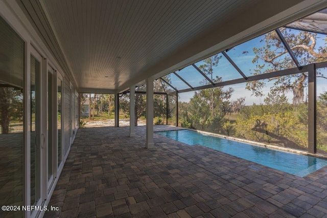 view of swimming pool with a patio and glass enclosure