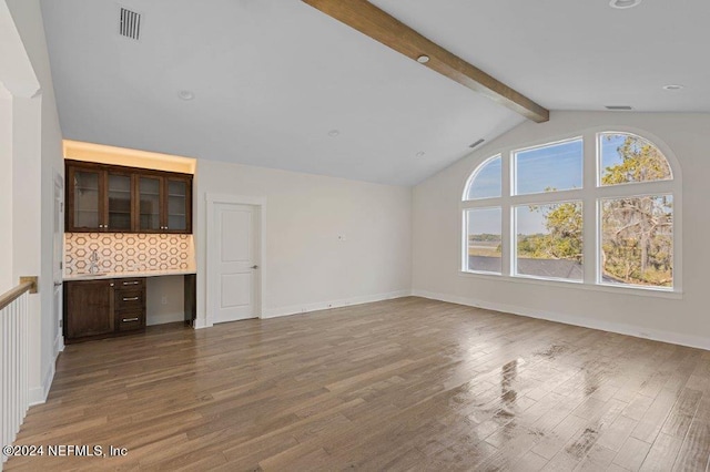 unfurnished living room with lofted ceiling with beams and wood-type flooring