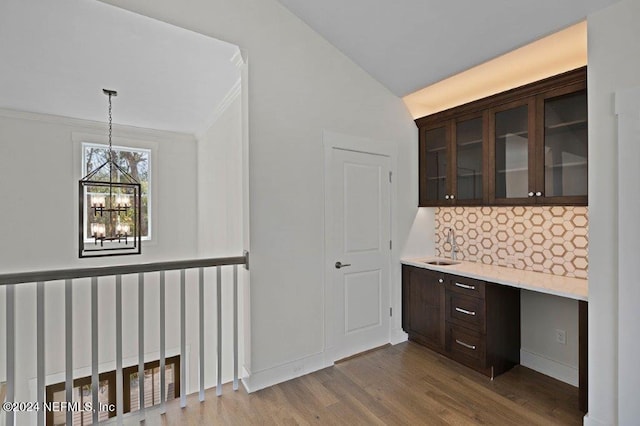 hallway featuring crown molding, hardwood / wood-style flooring, a chandelier, and sink