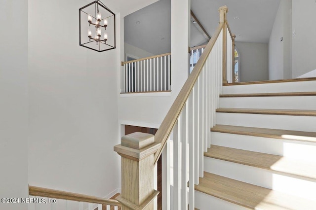 staircase featuring an inviting chandelier