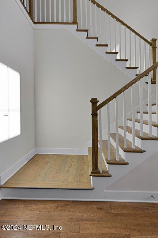 staircase with hardwood / wood-style floors