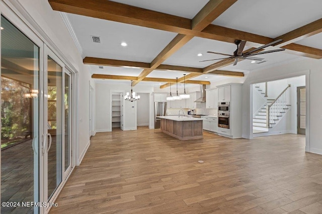 unfurnished living room featuring light hardwood / wood-style flooring, beamed ceiling, ceiling fan with notable chandelier, crown molding, and coffered ceiling