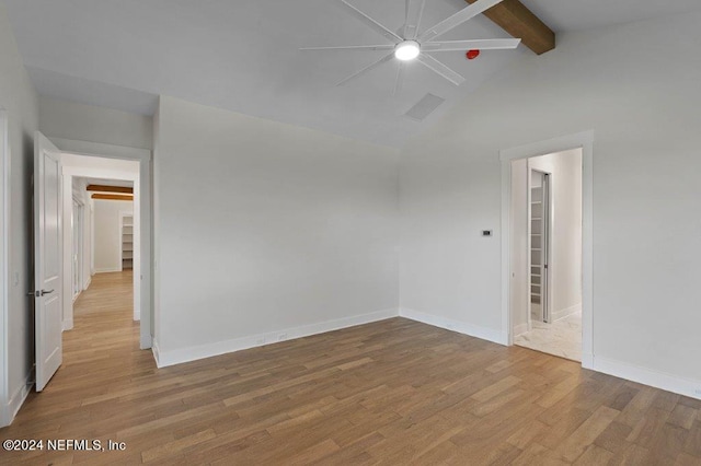 empty room with beam ceiling, high vaulted ceiling, light wood-type flooring, and ceiling fan