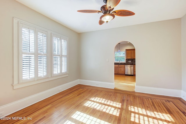 spare room with light hardwood / wood-style floors, sink, and ceiling fan