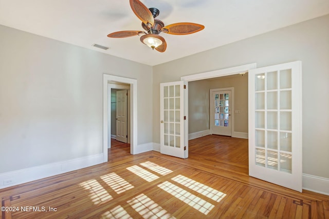 spare room featuring french doors, ceiling fan, and wood-type flooring