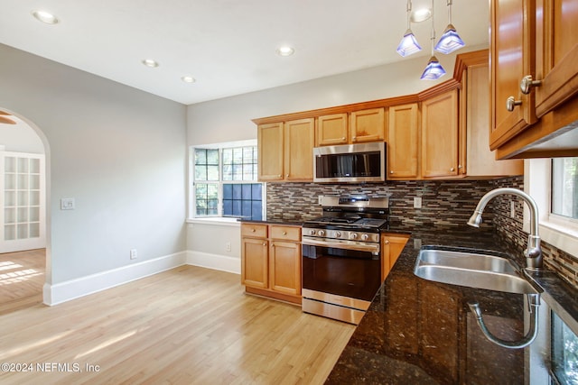 kitchen with appliances with stainless steel finishes, sink, plenty of natural light, and pendant lighting