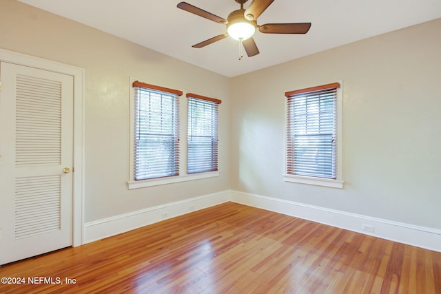 unfurnished room with hardwood / wood-style flooring, ceiling fan, and a healthy amount of sunlight