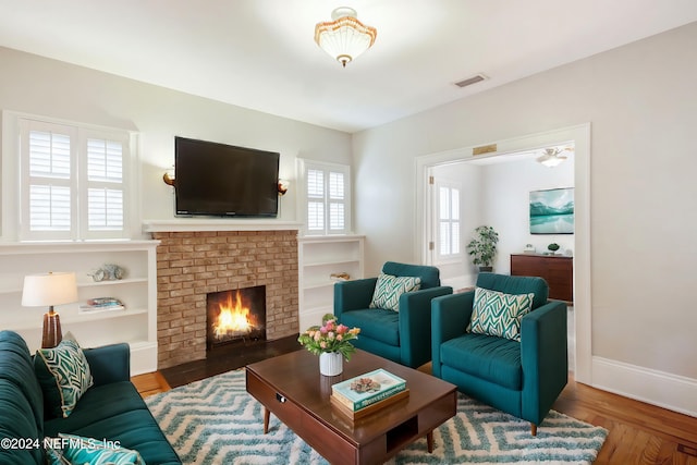 living room featuring a brick fireplace and hardwood / wood-style floors