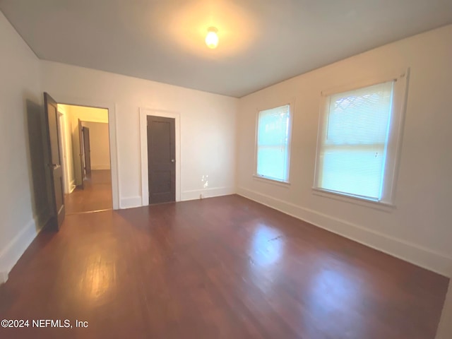 unfurnished bedroom with a closet and dark hardwood / wood-style flooring