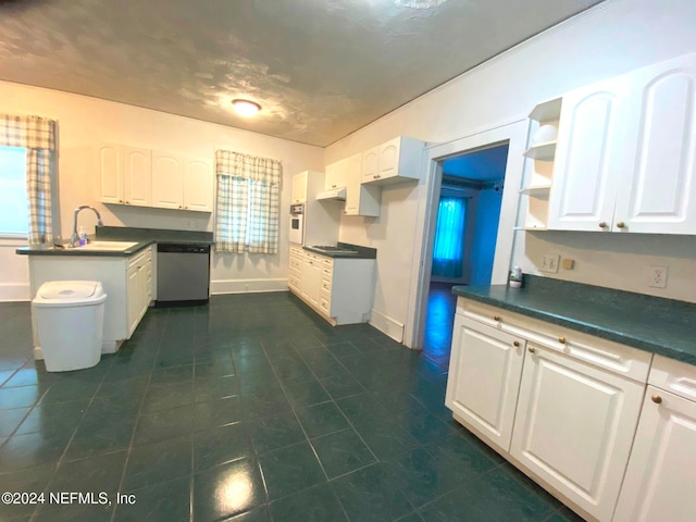 kitchen featuring white cabinets, white oven, stainless steel dishwasher, and sink