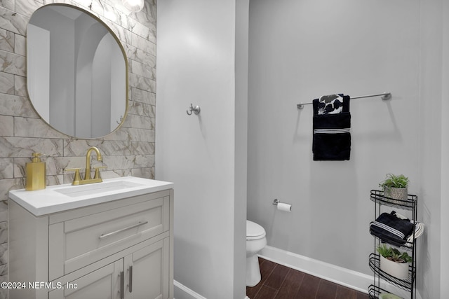 bathroom with toilet, tasteful backsplash, vanity, and hardwood / wood-style floors