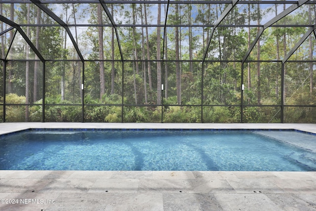 view of pool featuring glass enclosure